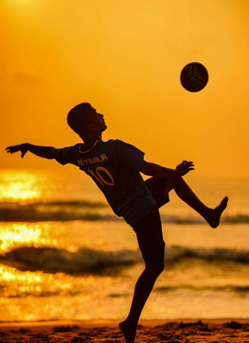 a man is playing with a ball on the beach
